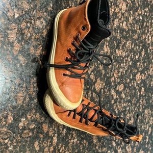 Brown leather Chuck  Taylor converse.